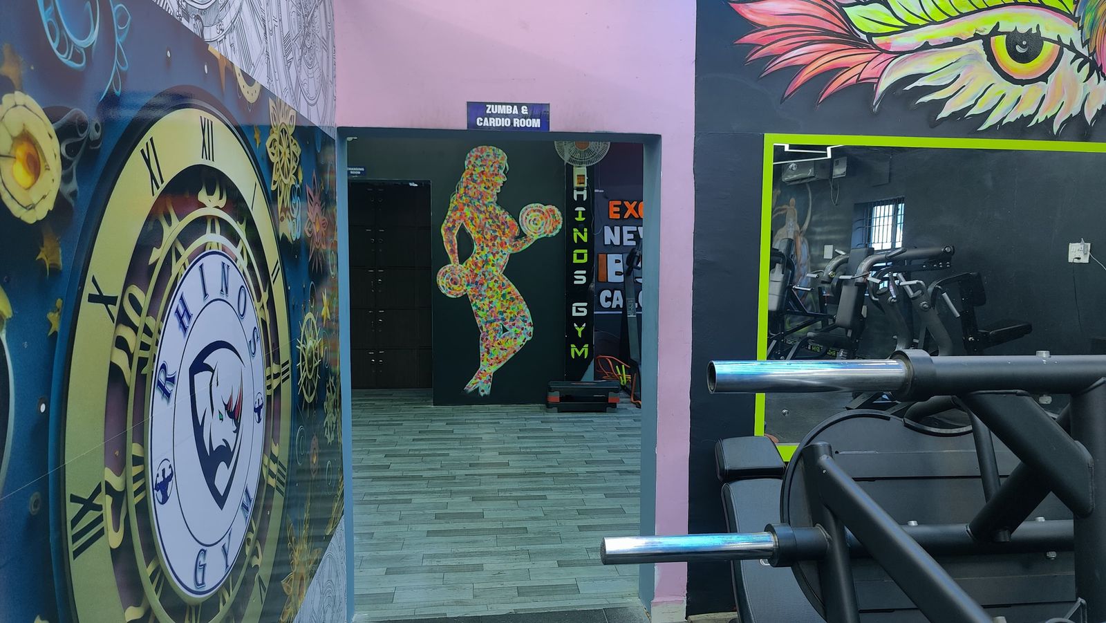 Clock-themed wall mural with the Rhinos Gym logo